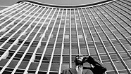 Photo of man on phone in front of skyscraper